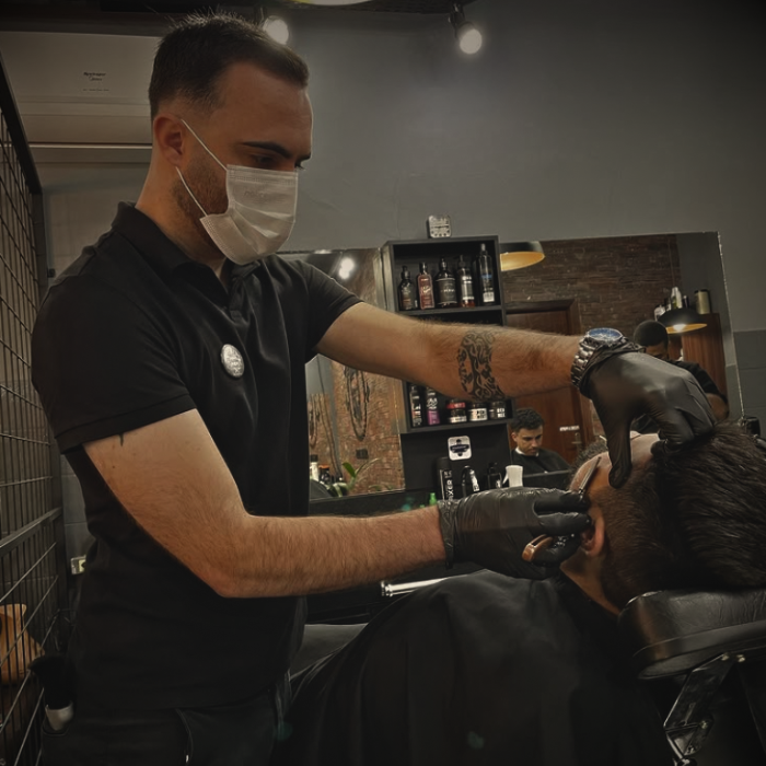 Barbeiro trabalhando em um cliente